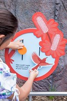 A child using an interactive that show a bird and flower motif, in the Gandel Gondwana Garden