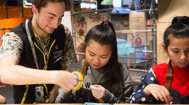 Two girls making a light-up card with a Scienceworks' staff member in Test Lab.