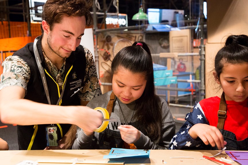 Two girls making a light-up card with a Scienceworks' staff member in Test Lab.