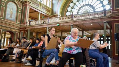 A group of art students drawing the ornate details of the Royal Exhibition Building ceiling.