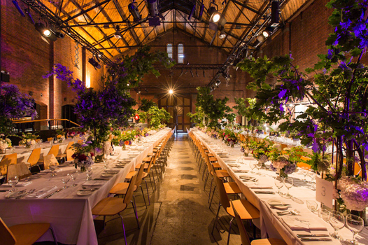 Long tables with white table clothes and large floral decorations