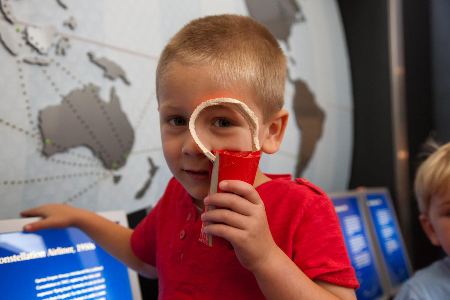 Small boy with a pretend magnifying glass.
