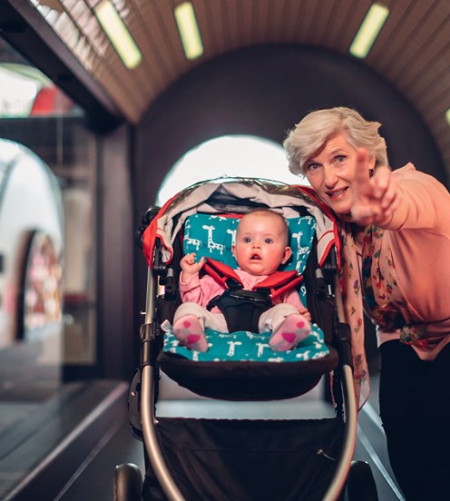Older Lady with a baby in a pram in the train tunnel exhibition
