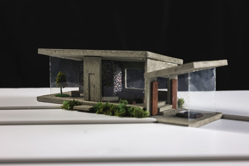 Architectural model of a geometric home with artificial garden and large windows.