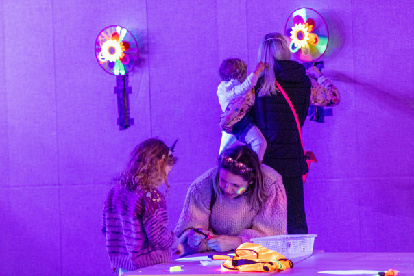 Children with adults exploring the Glow Lab activity held in the Energy Lab, during the 'Little Kids day In - Ready, Set, Glow' event at Scienceworks.