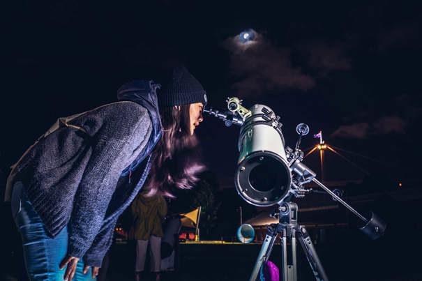 People enjoying the Valentine's Day themed events at Scienceworks, with staff providing a view of the skies with telescope.