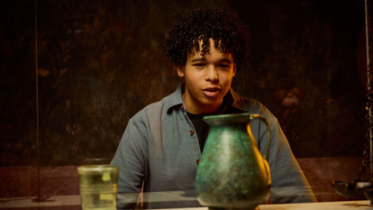 A child staring at a green roman jug in a display in ROME: Empire, People Power People Exhibition at Melbourne Museum
