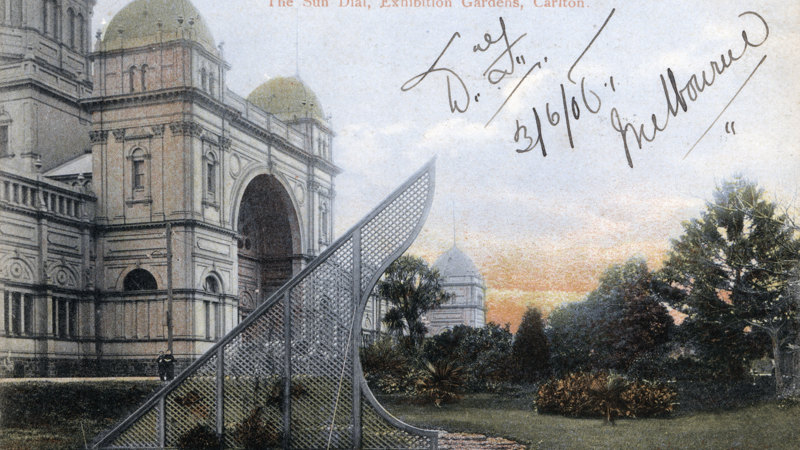 : Exhibition Building with lawn, trees and sundial in foreground.