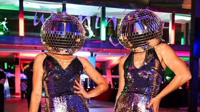 two people wearing disco clothing with disco balls on their heads during Discoteca Italiana, Melbourne Museum.