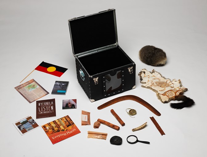 Black box with objects making up the First Peoples exhibition outreach kit arranged around it