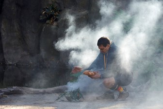 Man squat partially enclosed in smoke
