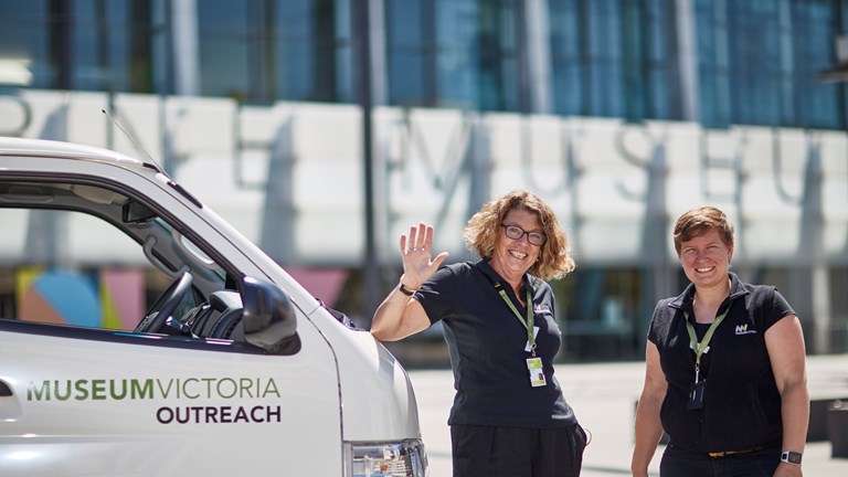 Outreach staff members Wendy Roberts and Krystal Kunig standing with the Outreach Van on the Melbourne Museum Plaza.