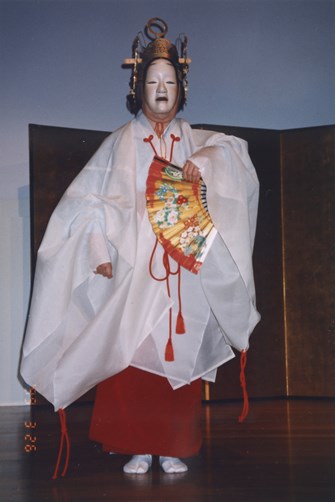 A woman on stage in traditional Japanese costume