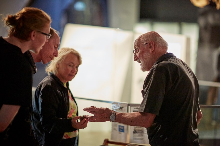 Visitors speaking with volunteer at a Melbourne Museum evening event.