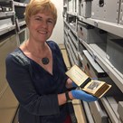 Woman in museum collection store showing and object