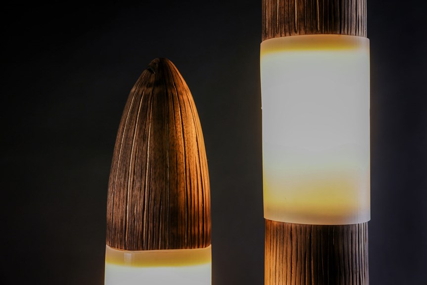 Top and centre views of two wooden standing lights with organic shapes.