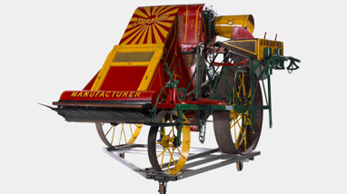 Red and yellow harvester on a museum trolley