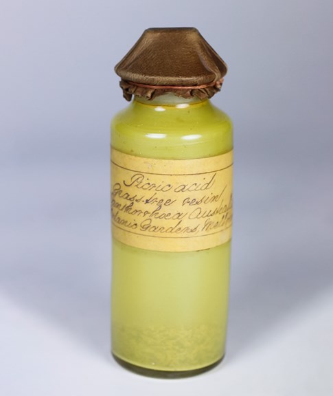 a glass vial of yellow powder