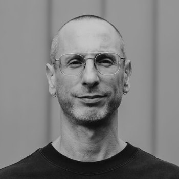 Black and white headshot of Elias wearing a black top.