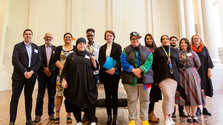 Group photo of the Inclusion Working Group in the Long Room of the Immigration Museum.
