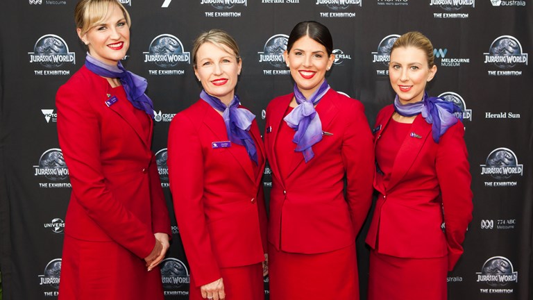 Four women dressed in red suits