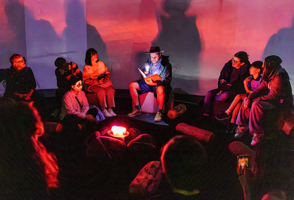 People enjoying a scary campfire story during Halloween at the Museum.
