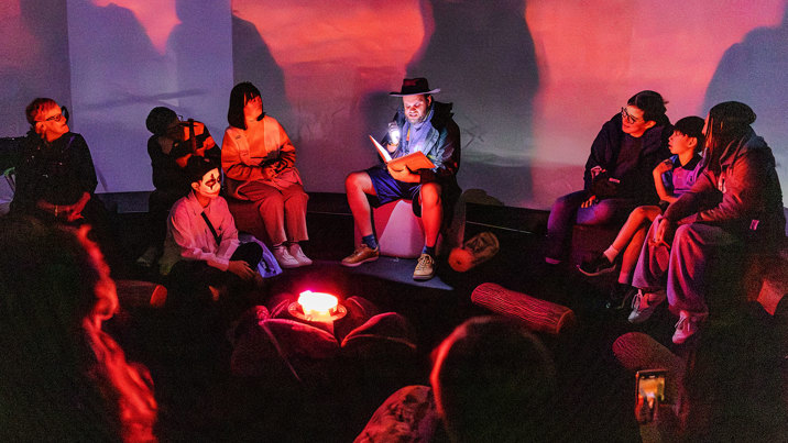 People enjoying a scary campfire story during Halloween at the Museum.