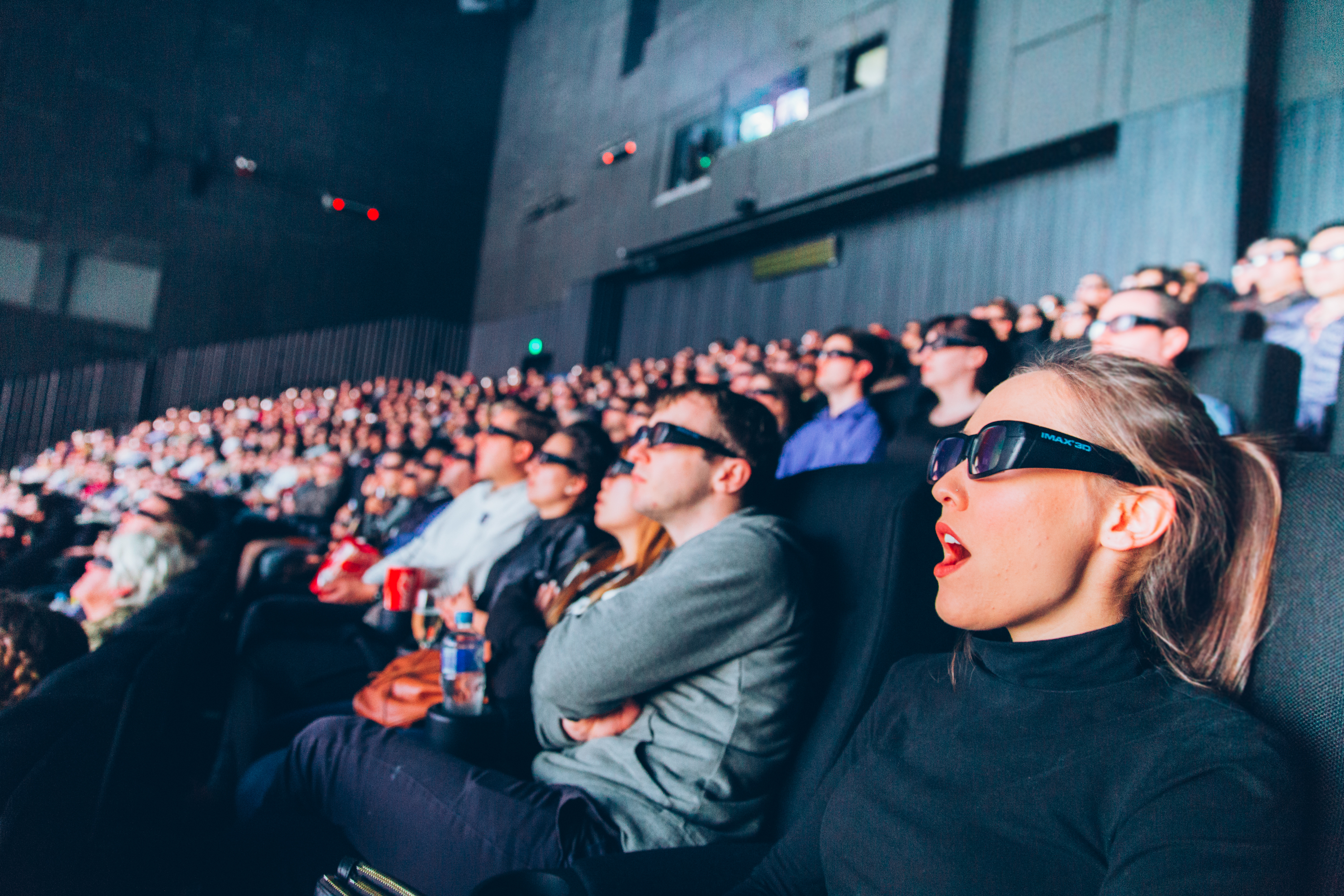 Crowd inside the IMAX theatre, wearing 3D glasses
