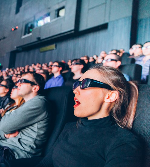 Crowd inside the IMAX theatre, wearing 3D glasses