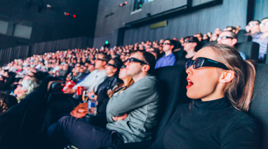 Crowd inside the IMAX theatre, wearing 3D glasses