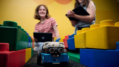 Young adults program a robot to navigate an obstacle course as part of Robots and Coding workshop at Scienceworks.