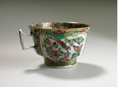 Teacup with a decorative floral design depicting a bird, butterflies, insects and flowers