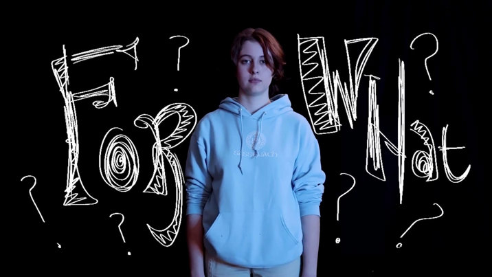 Film still showing a person in a light blue hoodie against a black background with white hand-drawn text and question marks surrounding them.
