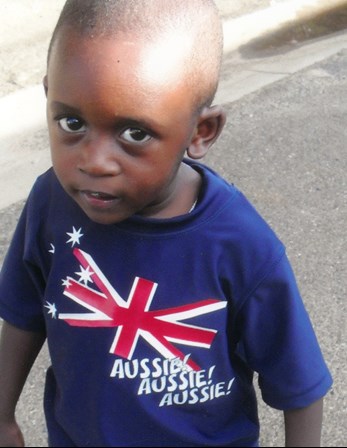 Photograph of Christian Mundabi wearing an 'Aussie! Aussie! Aussie!' T-Shirt. The frame of the photograph has been printed with a snowflake motif border.