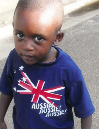Photograph of Christian Mundabi wearing an 'Aussie! Aussie! Aussie!' T-Shirt. The frame of the photograph has been printed with a snowflake motif border.