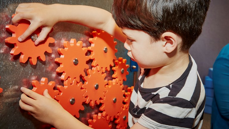 Boy playing with cogs