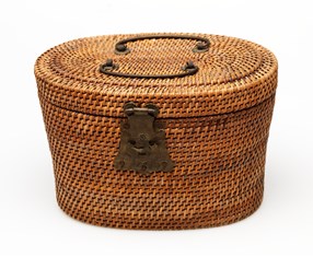 Part of a traditional Chinese tea set consisting of a ceramic tea pot, lid and two cups contained in a lined and padded woven rattan basket, possibly late nineteenth century. 
