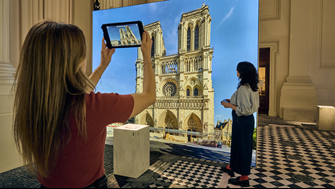 Notre Dame Exhibition visitor using augmented reality to view Notre Dame.