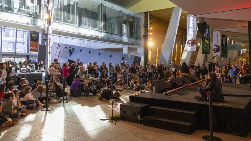 Audience at Melbourne Museum listening to a didgeridoo performance.