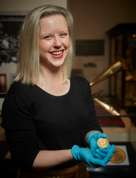 Michelle Stevenson holding a gold coin.