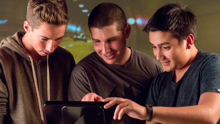 Three teenage boys looking at an iPad