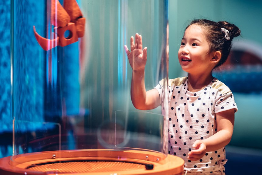 A girl plays with a flight tube inside children's gallery Ground Up: Building Big Ideas, Together at Scienceworks.