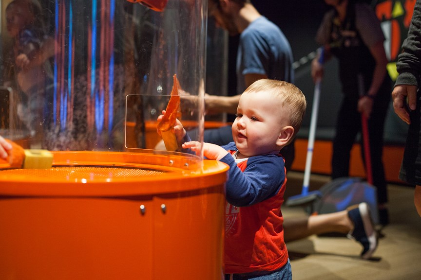Toddler playing with the suction tubes at the members' preview of the Ground Up exhibition at Scienceworks.