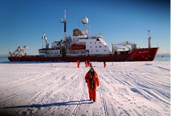 Melanie Mackenzie on the ice shelf in  front of the research vessel the James Clark Ross in Antarctica.