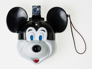 Black and white camera in shape of Mickey Mouse with flash at top of head and wrist strap.