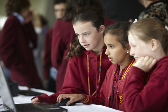 3 students sitting around a computer
