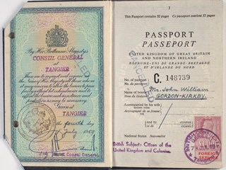 Black covered passport with United Kingdom Coat of Arms in gold on the cover. The inside of the passport contains personal details, immigration stamps and a photograph of the holder.