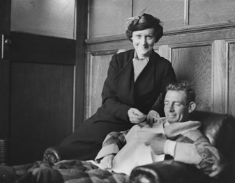 Man sitting in armchair with woman sitting alongside.