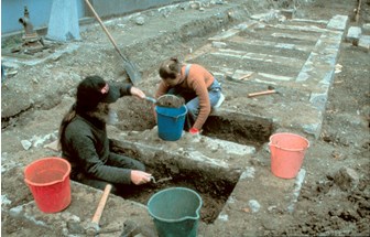 Two archaeologists digging pits
