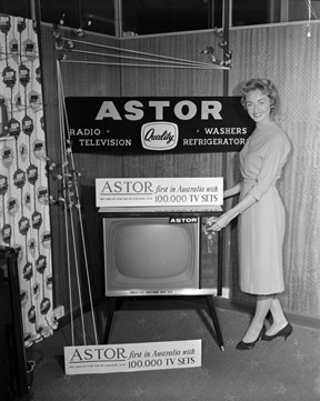 Woman Standing Next to an Astor Television Set.